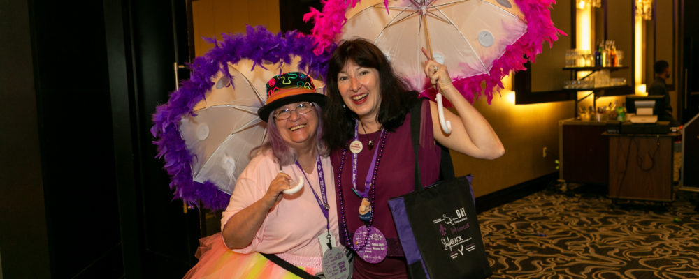 Author Alyssa J Montgomery and a volunteer get ready for Tina Desalvo's Second Line Band at BLC19